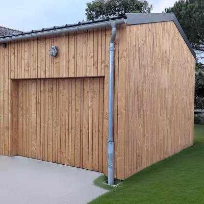 Porte de garage basculante en bois assortie à la façade