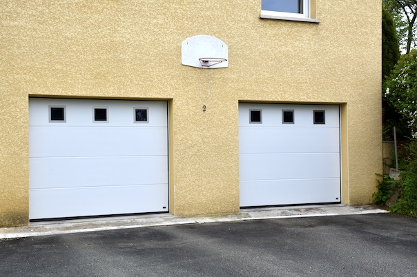 White sectional garage door with smooth panels without grooves and square alunox windows