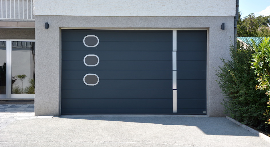 Charcoal grey sectional garage doors with aluminum portholes